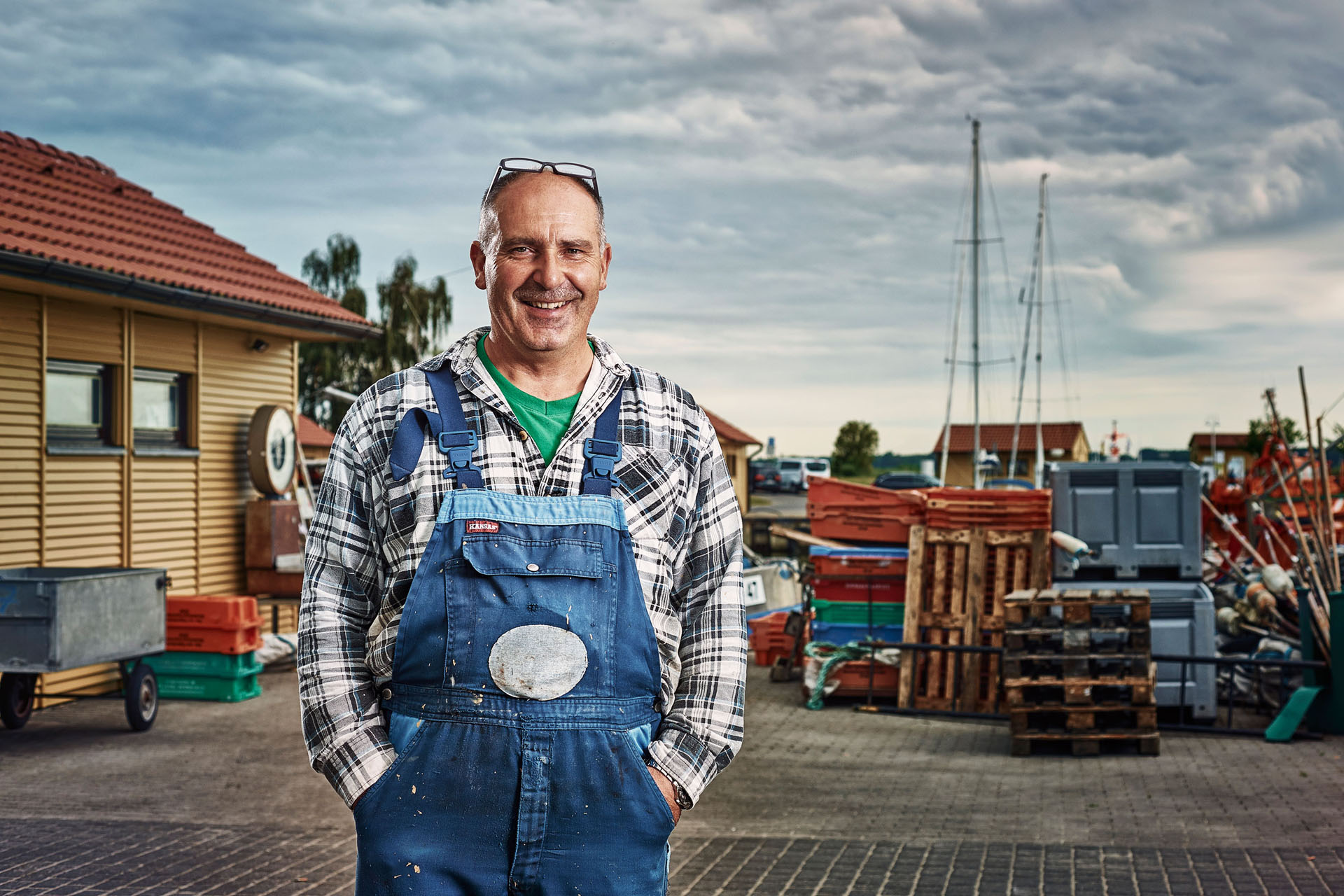 The fisherman Dirk Baumann with blue dungarees over a blue and white-checked flannel shirt.